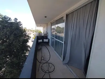 a balcony with two chairs and a large window at Depto VCP in Villa Carlos Paz
