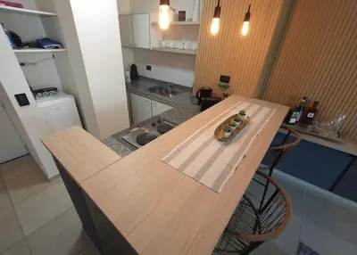 a wooden table in a kitchen with a counter top at Depto VCP in Villa Carlos Paz