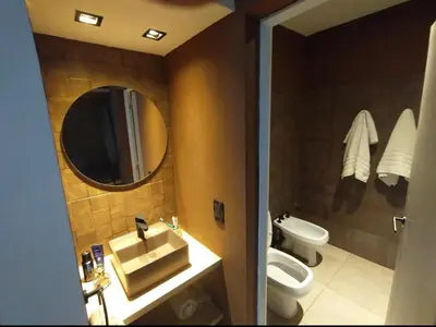 a bathroom with a sink and a toilet and a mirror at Depto VCP in Villa Carlos Paz