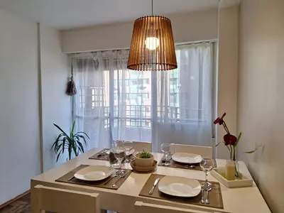 a dining room table with a chandelier above it at Excelente Depto - Patio Olmos in Cordoba