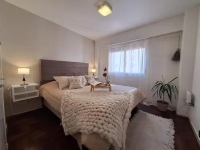 a bedroom with a large bed and a window at Excelente Depto - Patio Olmos in Cordoba