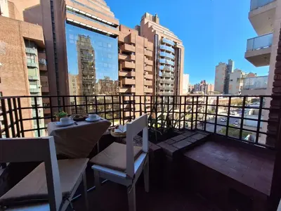 a balcony with a table and chairs on a balcony at Excelente Depto - Patio Olmos in Cordoba