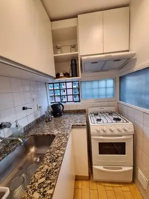 a kitchen with a stove and a sink at Excelente Depto - Patio Olmos in Cordoba