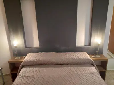 a bedroom with a bed with two lamps on both sides at Departamento Céntrico in Villa Carlos Paz