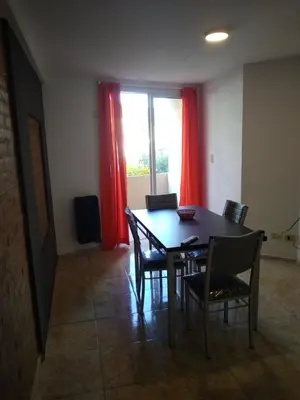 a dining room with a table and chairs and a window at Departamento Céntrico in Villa Carlos Paz