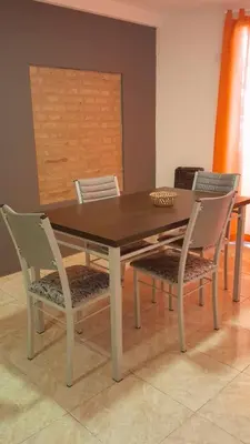 a dining room table with two chairs and a wooden table at Departamento Céntrico in Villa Carlos Paz
