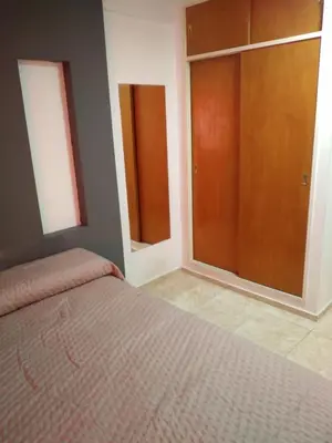 a bedroom with a bed and two sliding glass doors at Departamento Céntrico in Villa Carlos Paz