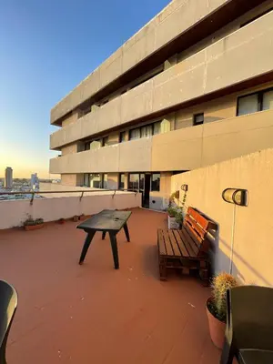 a bench and a table on the roof of a building at Departamento Centrico con terraza propia in Río Cuarto
