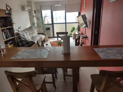 a living room with a wooden table and chairs at Departamento Centrico con terraza propia in Río Cuarto