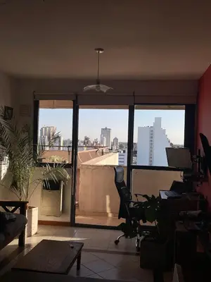 a room with a large window with a view of a city at Departamento Centrico con terraza propia in Río Cuarto