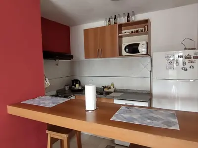 a kitchen with a wooden counter top with a refrigerator at Departamento Centrico con terraza propia in Río Cuarto