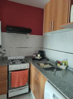 a kitchen with a stove top oven next to a sink at Departamento Centrico con terraza propia in Río Cuarto