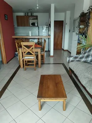 a living room with a table and a kitchen at Departamento Centrico con terraza propia in Río Cuarto