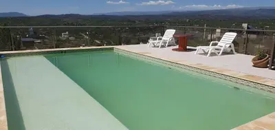 a swimming pool with chairs and a table on a balcony at Estancia de Campo in Estancia Vieja