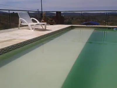 a white chair sitting next to a swimming pool at Estancia de Campo in Estancia Vieja