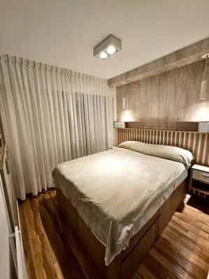 a bedroom with a large bed and curtains at Departamento cálido y tranquilo SS2 in Cordoba