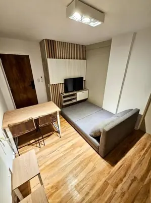 a room with a couch and a table and a television at Departamento cálido y tranquilo SS2 in Cordoba