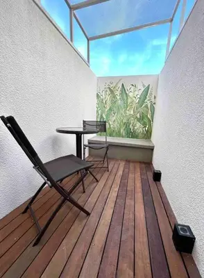 a room with a table and a chair on a wooden floor at Departamento cálido y tranquilo SS2 in Cordoba