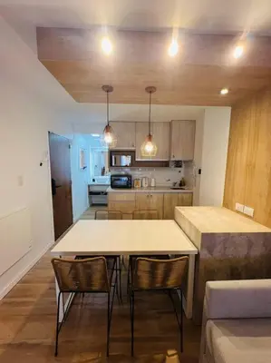 a kitchen with a table and chairs in a room at Departamento en hermosa zona de Nueva Córdoba. SS3 in Cordoba