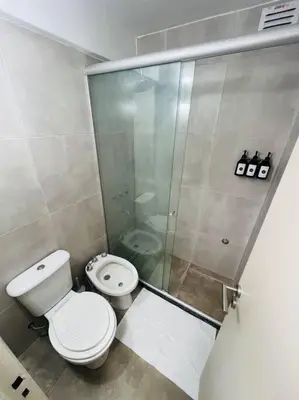 a bathroom with a toilet and a glass shower at Departamento en hermosa zona de Nueva Córdoba. SS3 in Cordoba