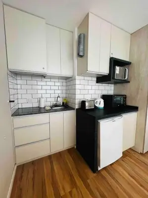 a kitchen with white cabinets and a black counter top at Estudio - apartamento renovado y confortable SS4 in Cordoba