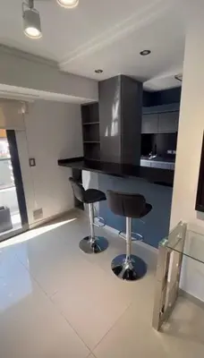 a kitchen with a black counter and two bar stools at Dpto Obispo Trejo - Nueva Cba - Alquiler mínimo por 3 meses in Cordoba