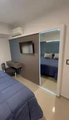 a bedroom with two beds and a mirror at Dpto Obispo Trejo - Nueva Cba - Alquiler mínimo por 3 meses in Cordoba