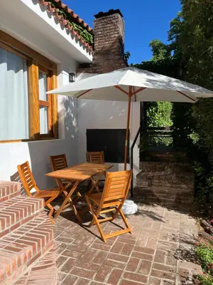 a table and chairs with an umbrella on a patio at Cabañas el Bierzo in Villa Cura Brochero