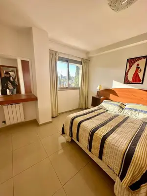 a large bedroom with a bed and a window at Depto 