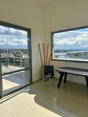 a room with a table and a chair and windows at Depto 
