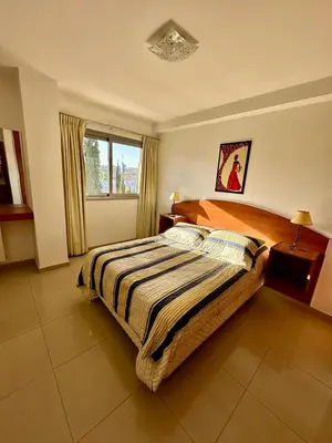 a bedroom with a large bed with a striped blanket at Depto 