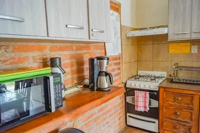 a kitchen counter with a microwave and a stove at Posada Tinktinkie in Santa Rosa de Calamuchita