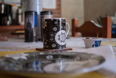 a black and white coffee mug sitting on a table at Posada Tinktinkie in Santa Rosa de Calamuchita