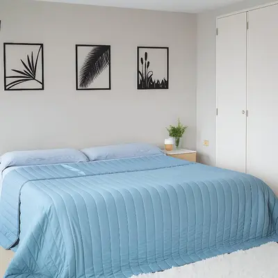 a white bedroom with a bed with a blue comforter at Coral State Premium Tower in Cordoba