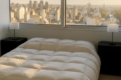 a bed in a room with a large window at Coral State Premium Tower in Cordoba