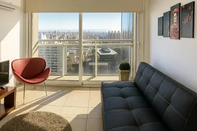 a living room with a couch and a large window at Coral State Premium Tower in Cordoba