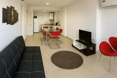 a living room with a couch and a table with chairs at Coral State Premium Tower in Cordoba