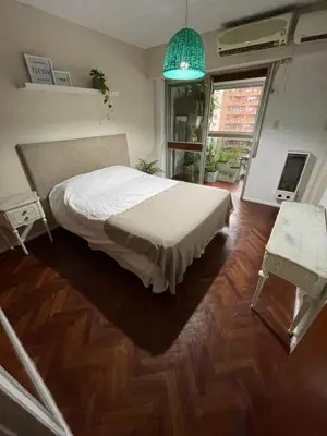 a bedroom with a bed and a large window at Depto Nva Cba mts Parque Sarmiento in Cordoba