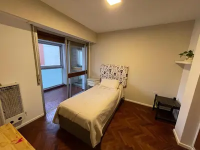 a bedroom with a bed and a large window at Depto Nva Cba mts Parque Sarmiento in Cordoba
