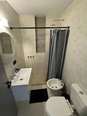 a bathroom with a toilet and a sink and a shower at Depto. 2 Dorm. premium vista Buen Pastor Av Yrigoyen in Cordoba