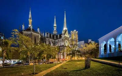 a large cathedral with spires in a city at night at Depto. 2 Dorm. premium vista Buen Pastor Av Yrigoyen in Cordoba