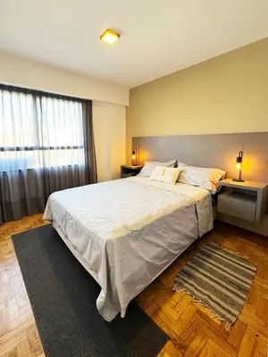a bedroom with a large bed with white sheets and pillows at Depto. 2 Dorm. premium vista Buen Pastor Av Yrigoyen in Cordoba