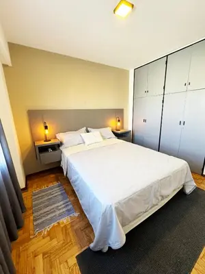 a bedroom with a large white bed and two lamps at Depto. 2 Dorm. premium vista Buen Pastor Av Yrigoyen in Cordoba
