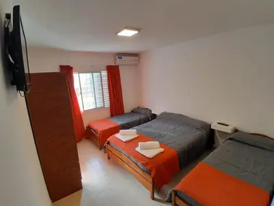 a small room with two beds and a television at HOTEL CRISTAL in Villa Carlos Paz