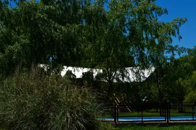 a tree and a fence in a park at La Argentina Complejo in Villa Ciudad de America