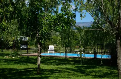 a swimming pool with a bench and a chair at La Argentina Complejo in Villa Ciudad de America