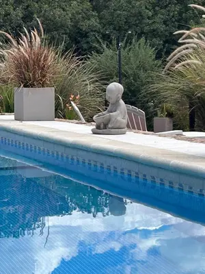 a statue sitting next to a swimming pool at Pueblo Santo, Cabañas & Suites in San Javier