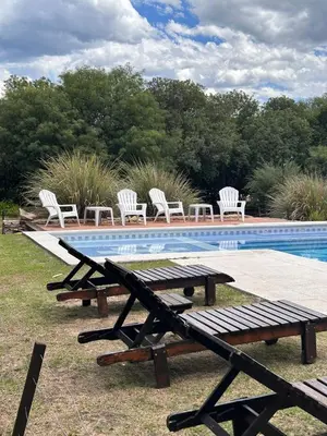 a picnic table and chairs next to a swimming pool at Pueblo Santo, Cabañas & Suites in San Javier