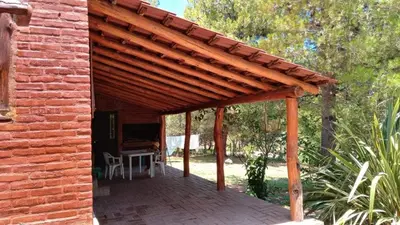 a wooden pergola attached to a brick building at Al pie del cerro in San Javier
