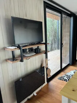 a living room with a tv and a sliding glass door at Casa Container Embalsina Villa del Dique in Villa del Dique
